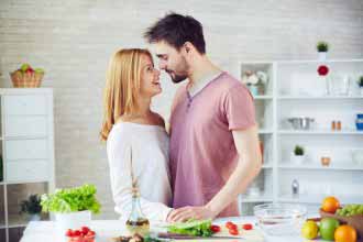 The couple in love kisses in kitchen
