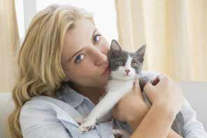 a beautiful blond lady kissing her cat